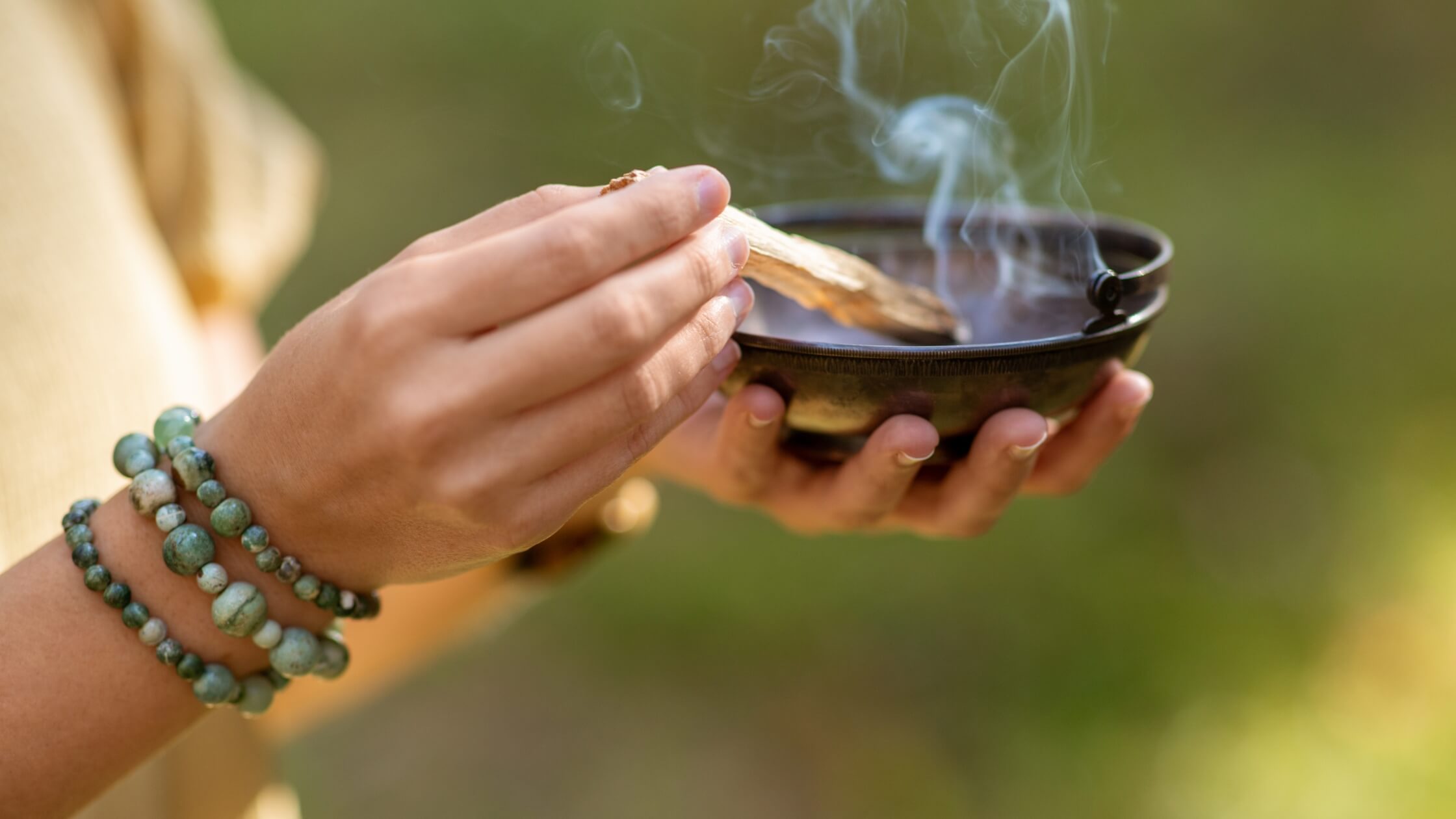 Räucherschale mit Rauch, verschiedene Kräuter in Schalen, Feder zum Wedeln, ritueller Aufbau