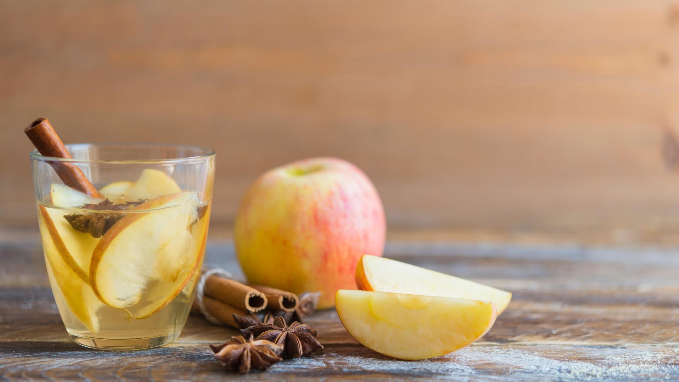 Dampfender Punsch in Gläsern, Zimtstangen, Abendstimmung