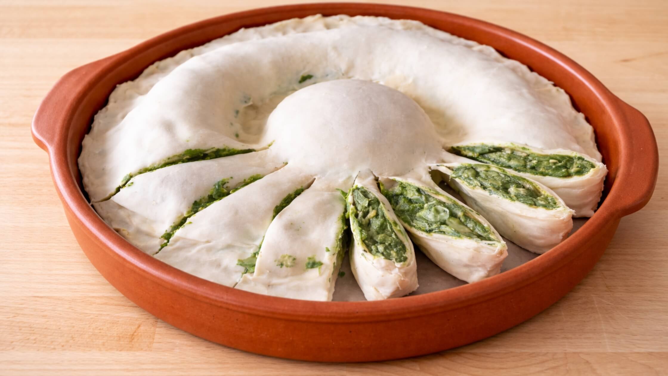 Fertige Spinatsonne auf Holzbrett angeschnitten Spirale sichtbar