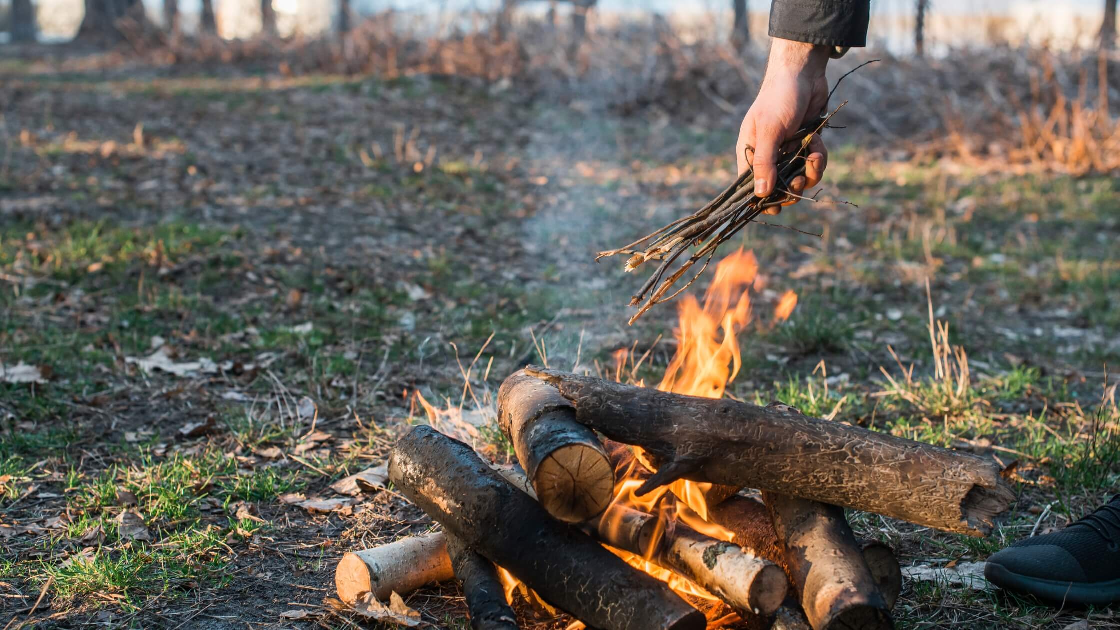 Großes Maifeuer bei Dämmerung zu Beltane mit Menschen im Kreis, traditionelles Ritual zum Sommeranfang, Walpurgisnacht Feier