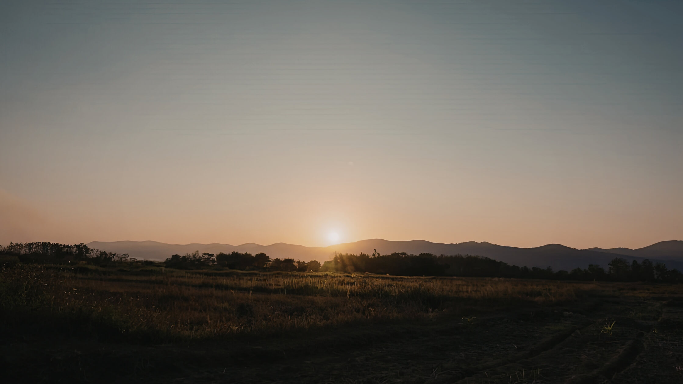 Sonnenuntergang über weiter Hügellandschaft symbolisiert Weite und Stille in der Geomantie
